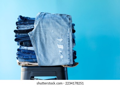 Stack of blue and brown jeans on chair show  for sell in a shop and supermarket. concept fashions jeans.
