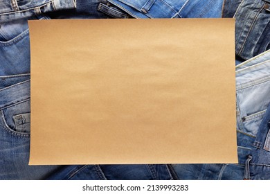 Stack Of Blue Jeans Denim And Craft Paper Name Plate. Jeans Heap With Parcel Paper Background