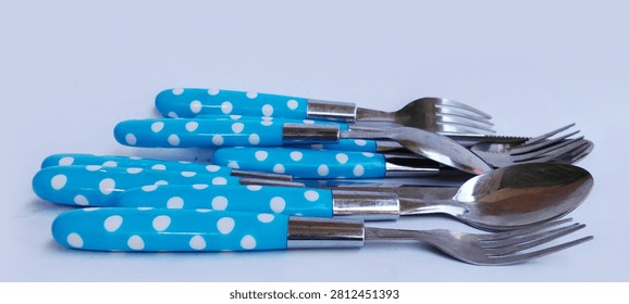 A stack of blue polka-dot patterned tableware sets on a white background.