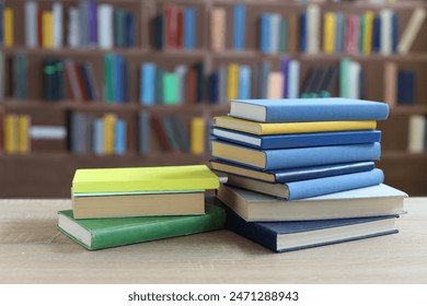  stack of books against the background of library, stack of books in front of library, books on wooden table, education, quality book photography - Powered by Shutterstock