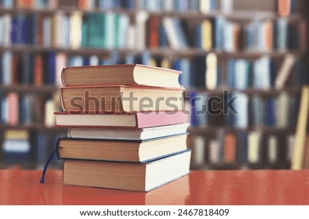 stack of books against the background of library, stack of books in front of library, books on wooden table