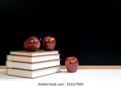 Stack Of Books With Apples And Blackboard/ Back To School