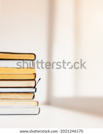 A stack of books by the window, Relaxation with reading books. Home education, reading, literature, study and knowledge concept. Copy space.