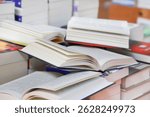 stack of books, close up. Open book on the table in library. Back to school concept. Open book on table with blur bookshelf background