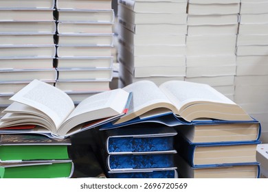 stack of books, close up. Open book on the table in library. Back to school concept. Open book on table with blur bookshelf background	
