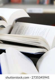 stack of books, close up. Open book on the table in library. Back to school concept. Open book on table with blur bookshelf background