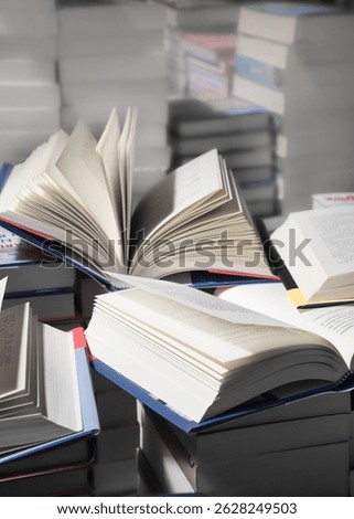 stack of books, close up. Open book on the table in library. Back to school concept. Open book on table with blur bookshelf background