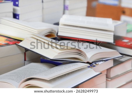 stack of books, close up. Open book on the table in library. Back to school concept. Open book on table with blur bookshelf background