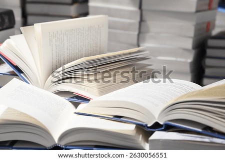 stack of books, close up. Open book on the table in library. Back to school concept. Open book on table with blur bookshelf background