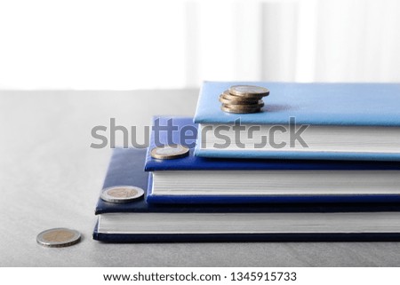 Stack of books with coins on table. Concept of career