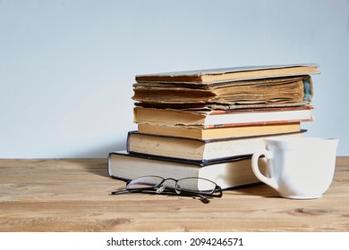 stack of books with a cup and glasses next to it. Space for text. The concept of training and education.