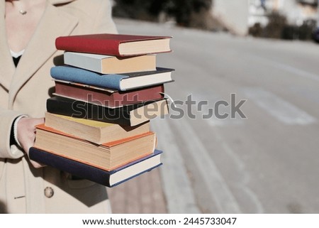 stack of books in hands of student, stack of books on color background, education, school,
