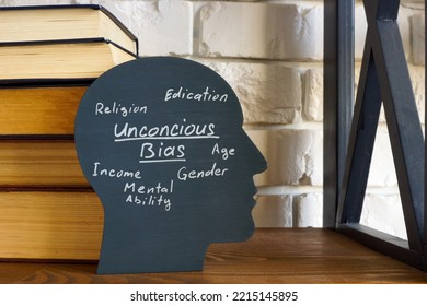 A stack of books and a head with an inscription unconscious bias. - Shutterstock ID 2215145895