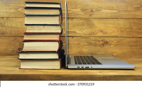 Stack Of Books And Laptop On Wooden Table 