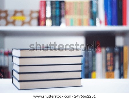 Stack of books in the library against the background of a bookcase
