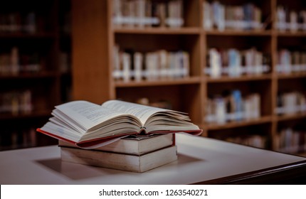 Stack of books in the library and blur bookshelf background