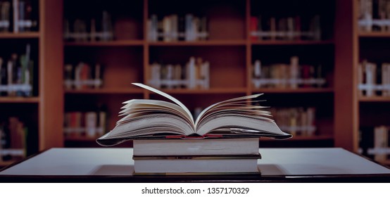 Stack of books in the library and blur bookshelf background - Shutterstock ID 1357170329