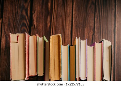 Stack of books in the library room lay on the wood table with brick backround.