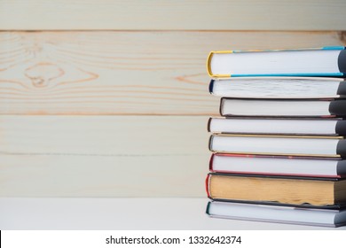 A stack of books lying on the table on a light wooden background. Back to school. Education background.