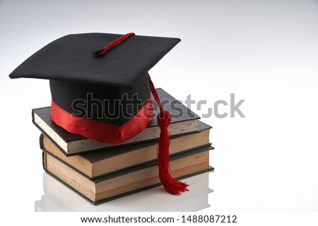 stack of books and mortarboard on the white background