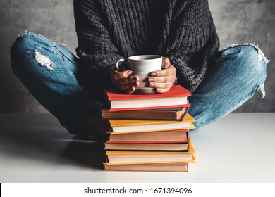 Stack Of Books With Mug On Top In Front Of Woman Reading Book, Education, Training, Hobbies