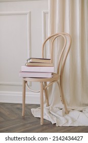 A Stack Of Books On A Beautiful Wooden Chair In The Interior.