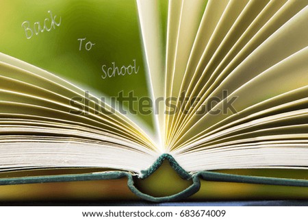 Stack of books on green background with concept back to school