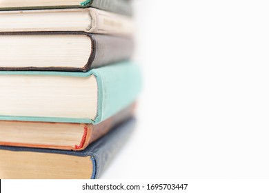 A stack of books on an isolated white background, the background of education, the concept of going back to school. A stack of colorful real books on a white background, partial view