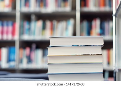 Stack of books on a shelf in a table.