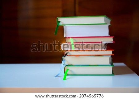 Stack of books on the table against the wooden background.  