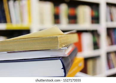 Stack of books on table in library - Shutterstock ID 1527173555