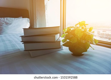 Stack of books on the white bed.  Soft focus, Vintage and grainy effect.