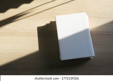 A Stack Of Books On A Wooden Desk
