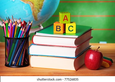 Stack of books, red apple, globe and pencils - Powered by Shutterstock