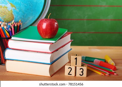 Stack of books, red apple, globe and pencils - Powered by Shutterstock