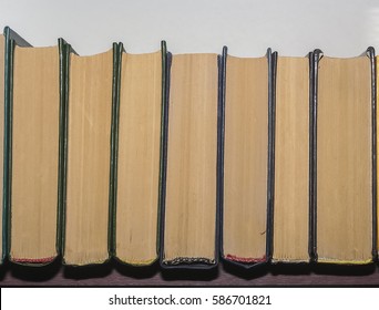 a stack of books standing on a shelf, assorted colors