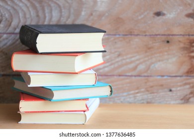 Stack of books in various colors Old wooden floor as background selective focus and shallow depth of field