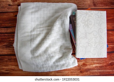 Stack of books with woolen blanket on the wooden table