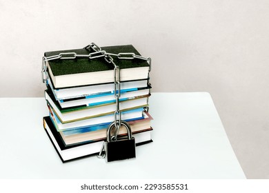 stack of books wrapped in a chain and padlocked.