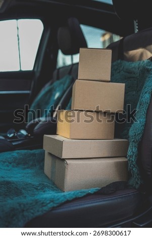 A stack of boxes sits on a car seat, suggesting a move or delivery is about to happen