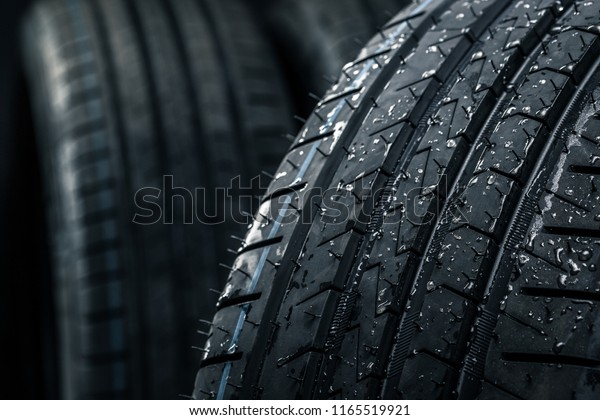 Stack of brand new high performance car\
tires on clean high-key white studio\
background