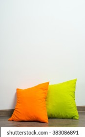 Stack Of Bright Pillows On Wooden Floor