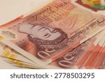 Stack of British fifty-pound banknotes featuring Queen Elizabeth II.