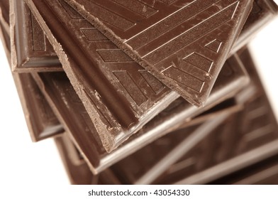 Stack of broken dark chocolate bar close-up.