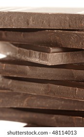 Stack of broken dark chocolate bar close-up.