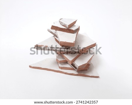 Stack of broken white ceramic tiles on white background, conceptual metaphor for mental health recovery, reconstruction, and construction waste
