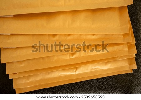 Stack of  brown air cushion envelopes on black leather background.