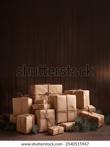 stack of brown kraft paper boxes gift wrap packages tied with jute string with pine boughs and wall space to add text for social media post