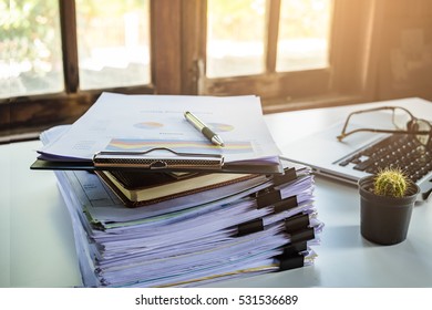 Stack Of Business Report Paper File On Modern White Office Desk With Laptop Computer.Close Up Business Concept.