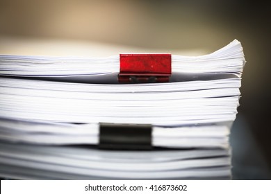 Stack Of Business Report Paper Files With Red And Black Clips